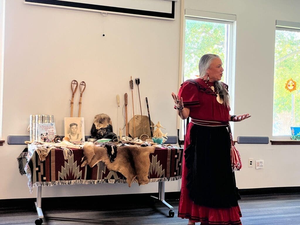 Native American woman speaks to fourth and fifth graders on field trip at progressive school.
