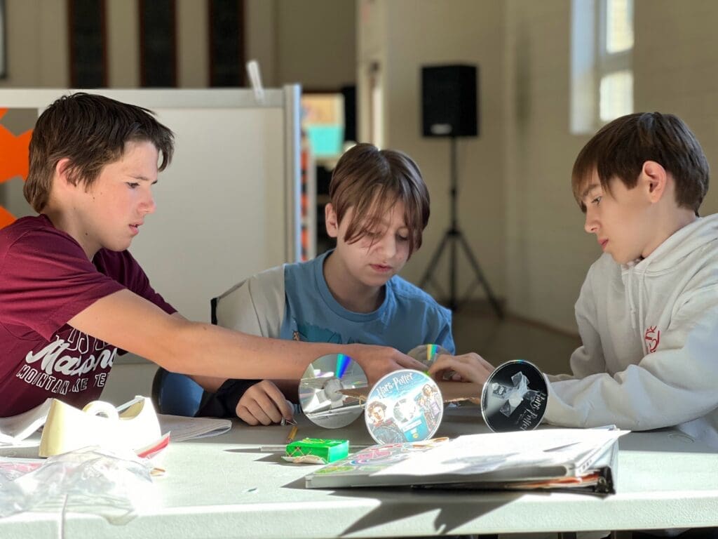 Private middle school students collaborate while building car.