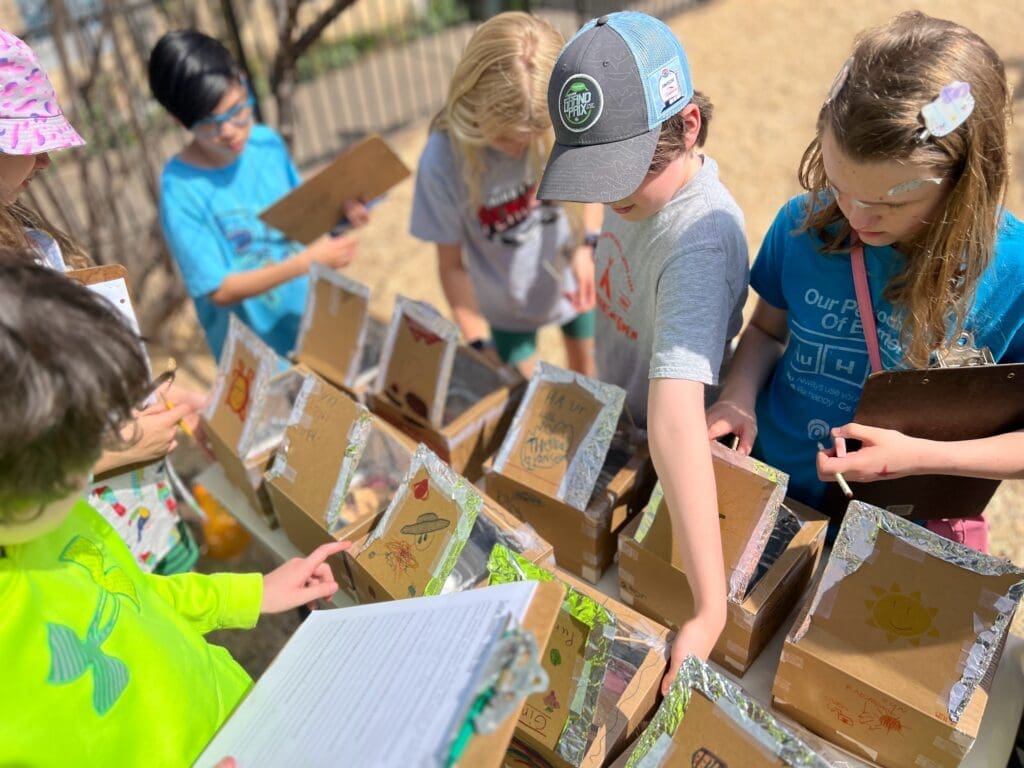 Middle schoolers inspect their solar ovens at progressive private school.
