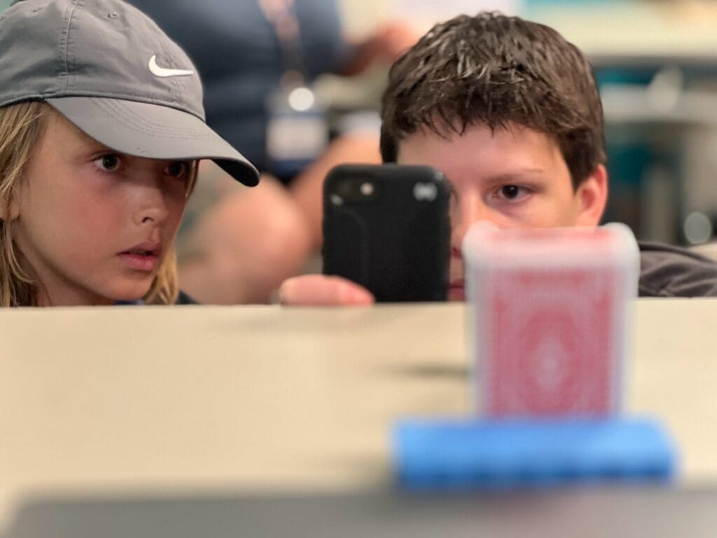 Two sixth grade boys recreate eclipse using household goods at progressive private school in Austin.