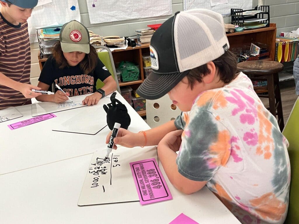 Fourth grade student works on math at table at private elementary school in Austin.