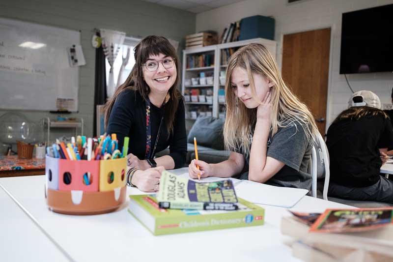 Elementary student works on writing skills at progressive school.