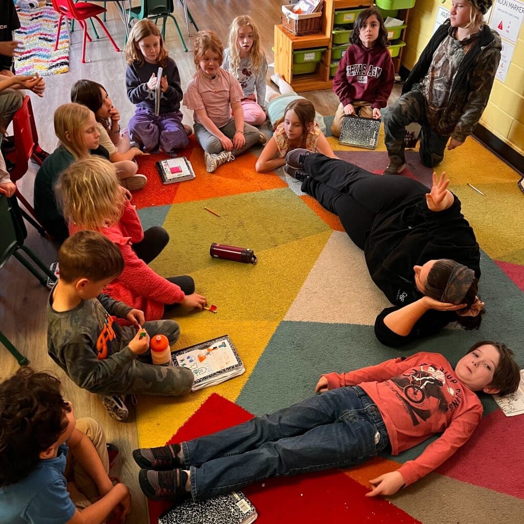 Second grade students create circle on rug at private school in Austin.