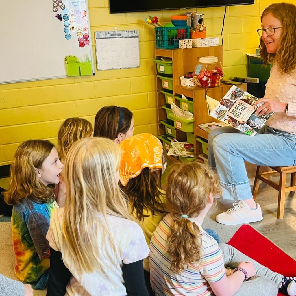 Elementary teacher reads to students at project-based school.