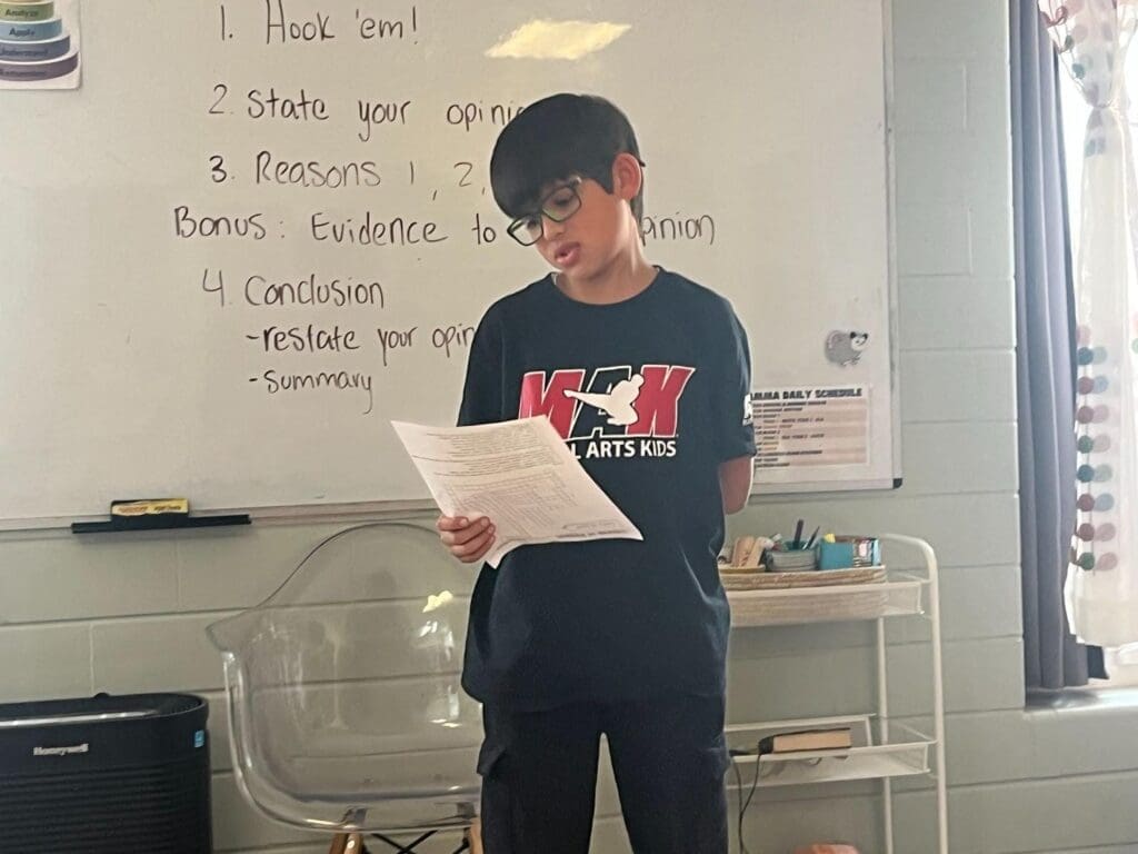 Elementary student gives presentation at project based school.
