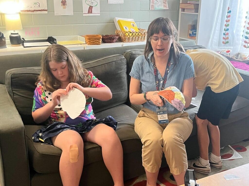 Elementary student works with teacher at school with small class sizes