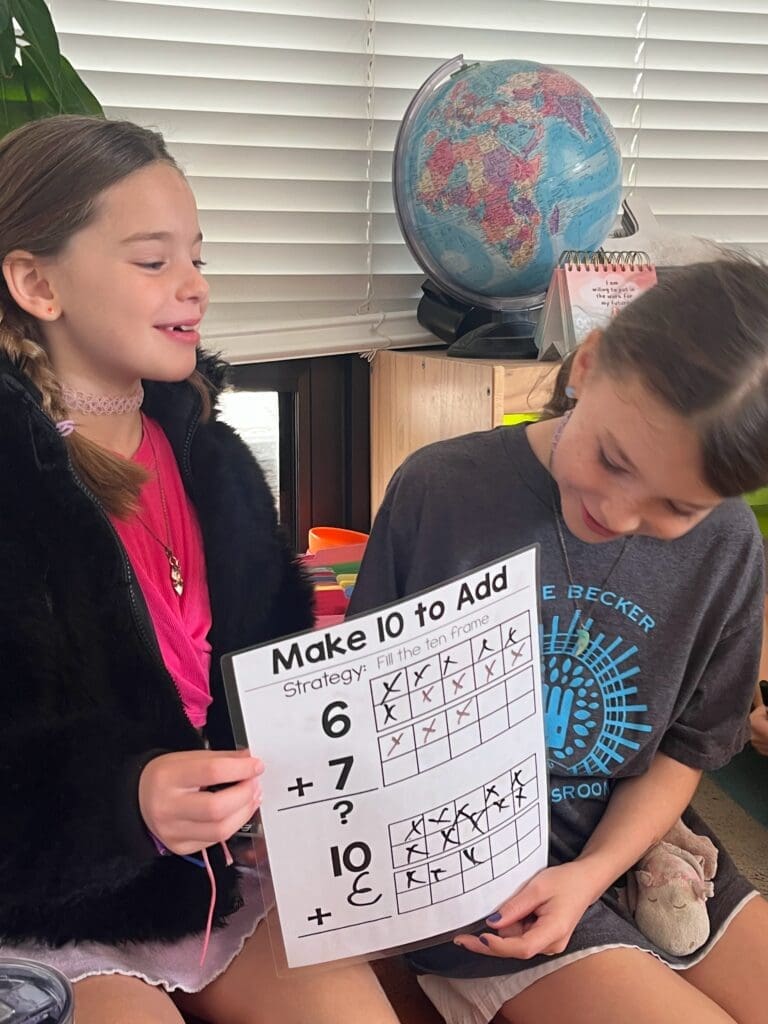 Two elementary students display math work at STEM school.