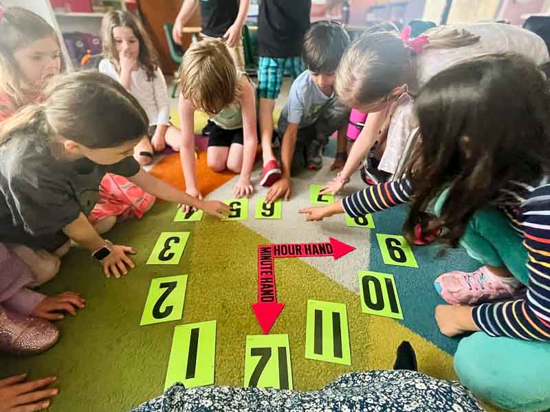Elementary students work on making clock.