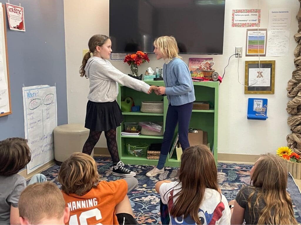 Two elementary students perform in front of class at micro school.