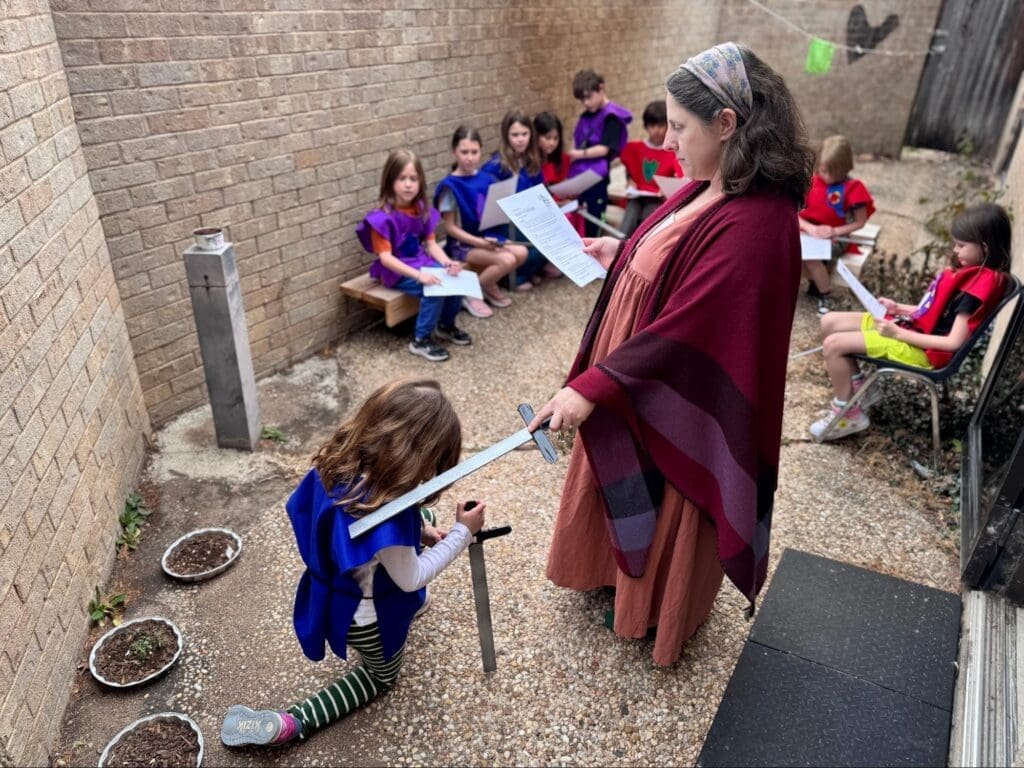 Elementary teacher knights student as part of project based learning.