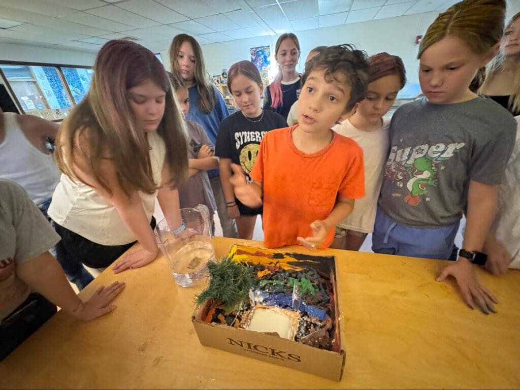 Middle school student explains to other students at project based school.