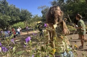 Middle school student stands among flowers at nonreligious school.