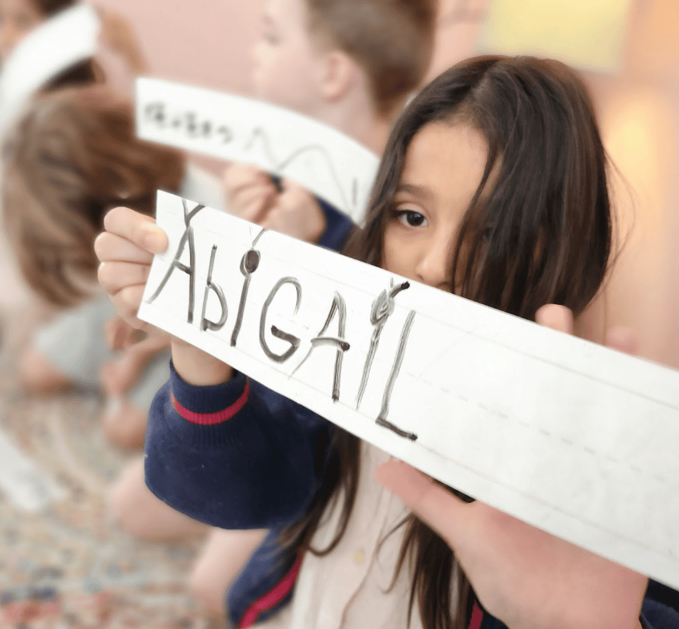 Kindergarten students write their names at half day program in Austin