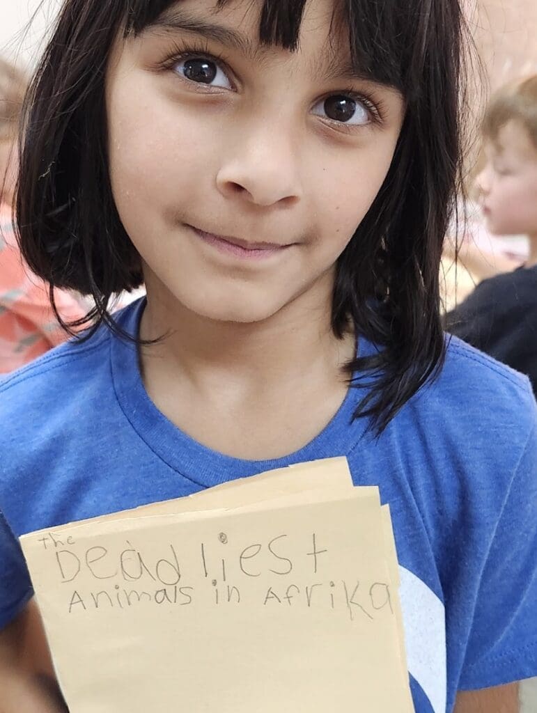 Kindergarten student displays writing at private school in Austin.